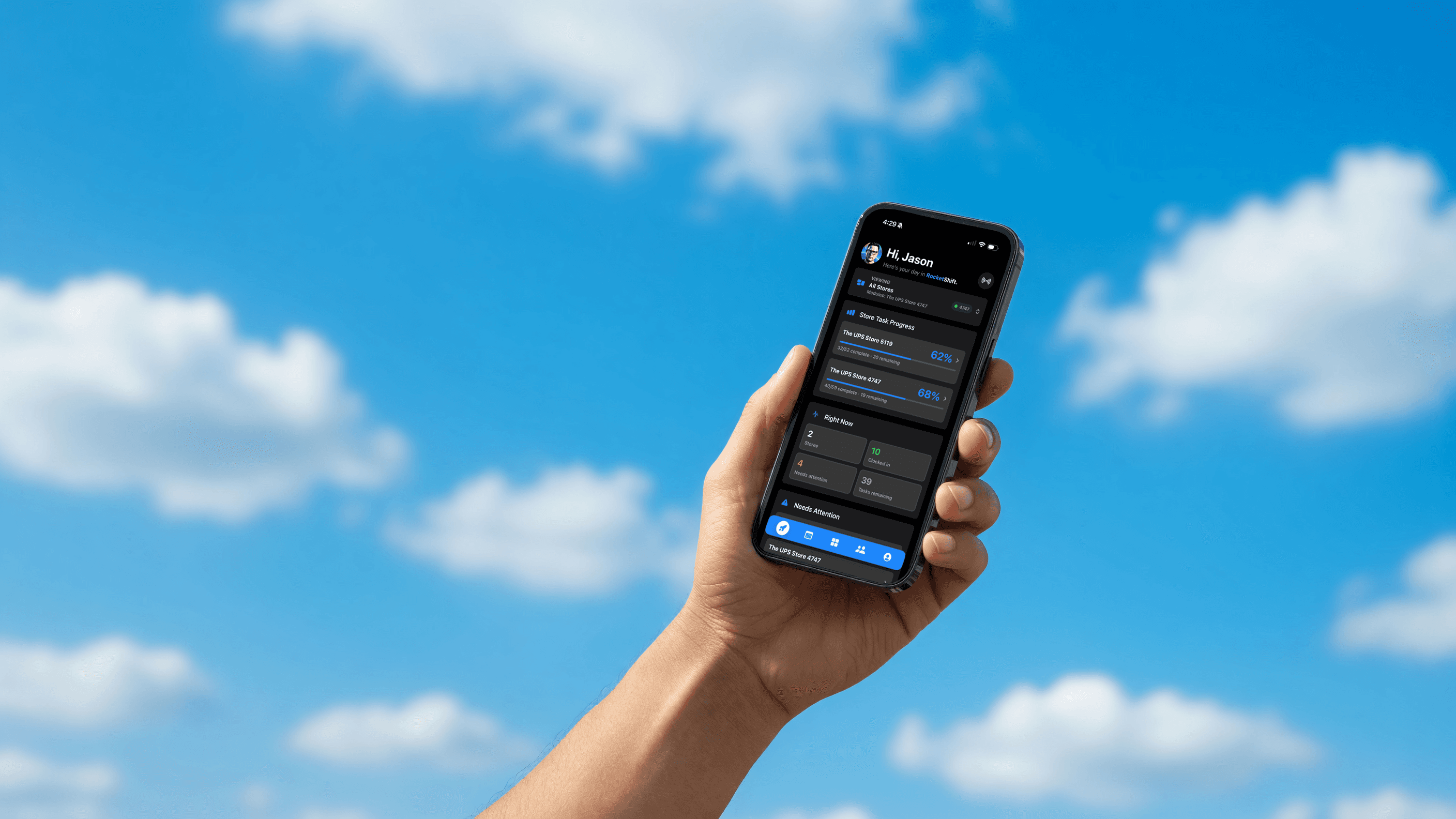 A hand holds an iPhone showing RocketShift against a blue sky